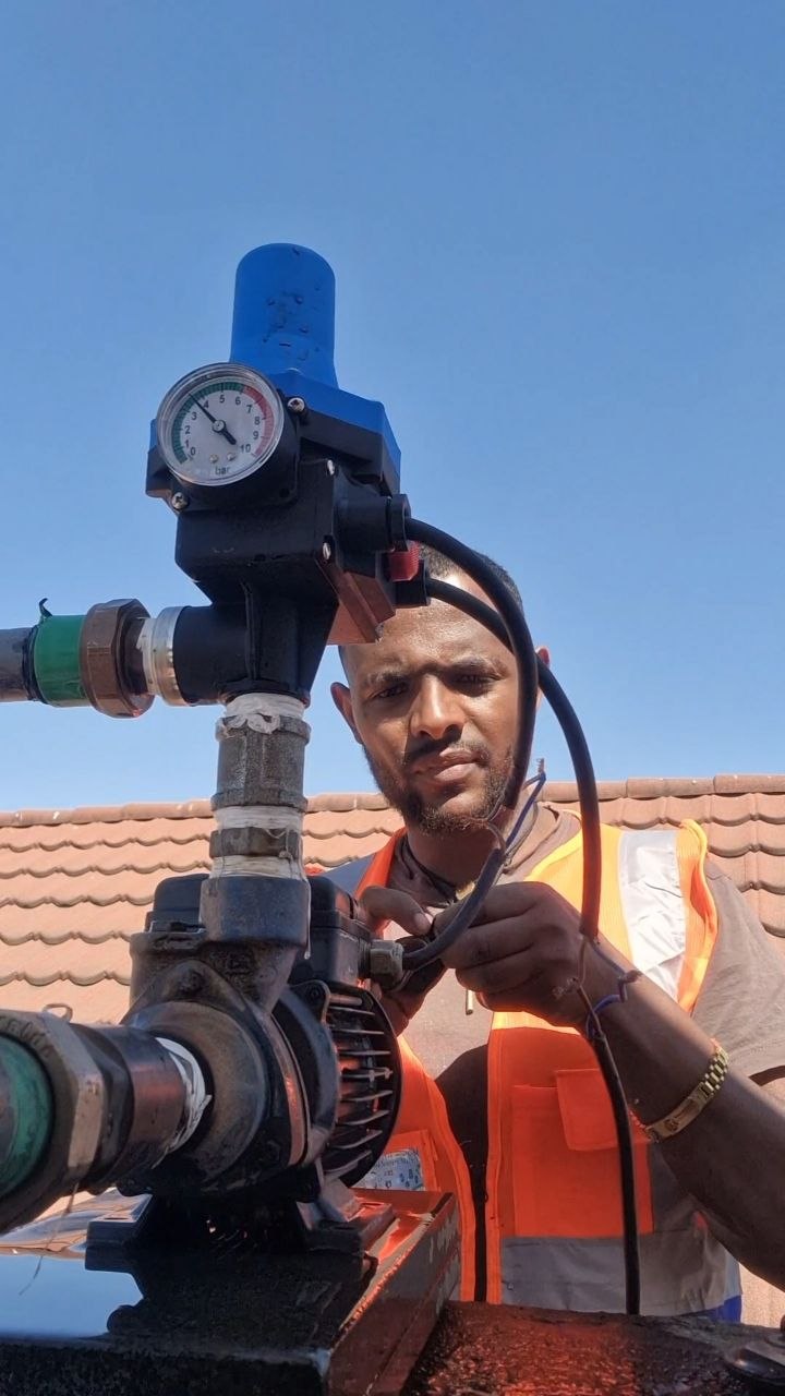 Technician servicing rooftop pressure pump