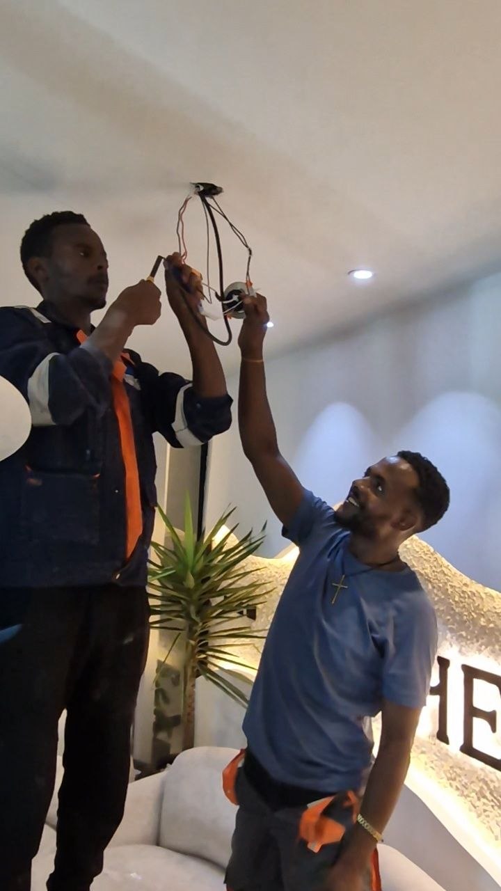 Team installing ceiling light fixture