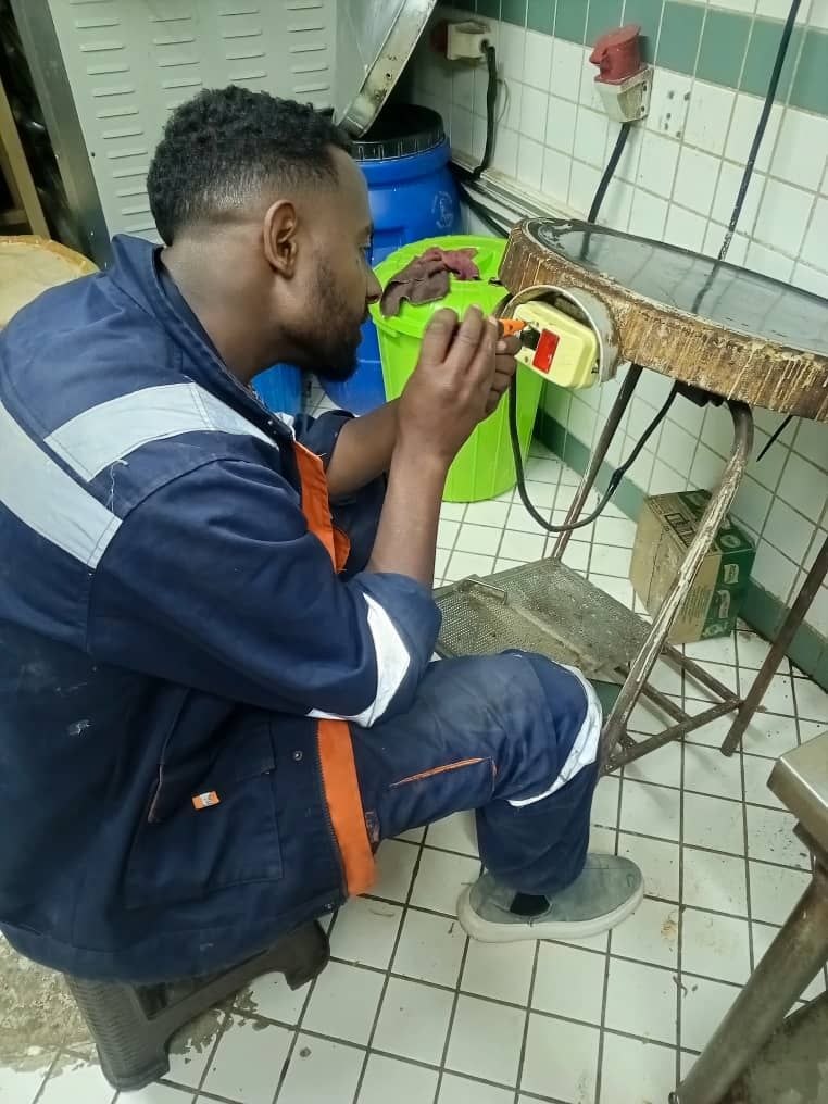 Technician repairing kitchen equipment wiring
